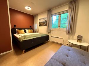 a bedroom with a bed and a table and a window at Nidaros Pilegrimsgård in Trondheim