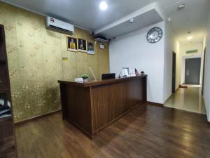 an office with a reception desk and a clock on the wall at Hotel Arba in Kuala Lumpur