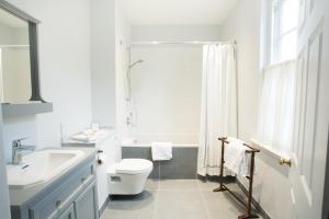 a white bathroom with a toilet and a sink at The Old Rectory in Campsey Ash