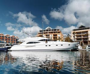 a white boat is docked in a harbor at Only One Yacht Cape Town in Cape Town