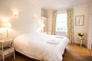 a bedroom with a white bed and a window at The Old Rectory in Campsey Ash