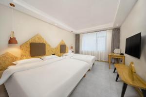 a hotel room with three beds and a television at Jianshanxi Designer Hotel in Mount Siguniang