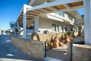 a house with potted plants sitting outside of it at Adriana beach in Pefkochori