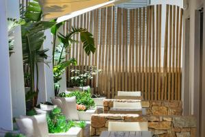 a lobby with white chairs and plants at Adriana beach in Pefkochori +100 photos