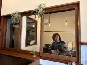 a woman is taking a picture in a mirror at New open - ねどことあさげナマケモノ Nedoko & Asage by Sloth - Japanese Traditional House in Ōno