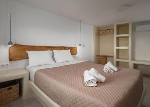 a bedroom with a bed with towels on it at Falcon Eyes- Panoramic stone house in Andros