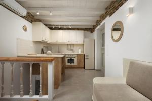 a kitchen with white cabinets and a counter top at Falcon Eyes- Panoramic stone house in Andros