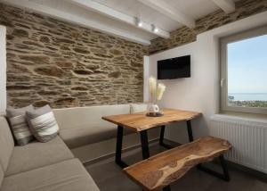 a living room with a couch and a table at Falcon Eyes- Panoramic stone house in Andros