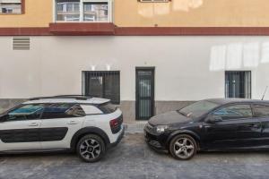 two cars parked in a parking lot in front of a building at Modern Loft in Málaga in Málaga