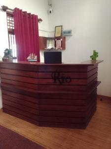 a reception desk in a room with a red curtain at Rio Lake Hotel Sigiriya in Habarana