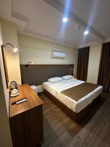 a bedroom with a large bed and a wooden table at Fırat Otel in Marmaris +4 photos
