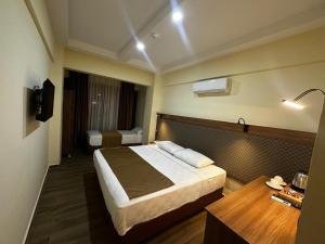 a bedroom with a bed and a desk with a lamp at Fırat Otel in Marmaris