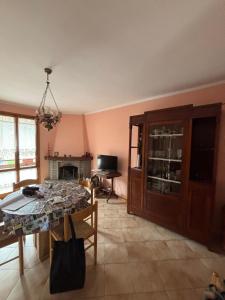 a dining room with a table and a chandelier at Claudia F in Pievepelago