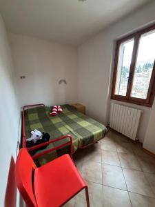 a bedroom with a bed and a red chair at Claudia F in Pievepelago