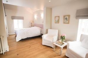 a bedroom with a bed and a chair and a couch at The Old Rectory in Campsey Ash