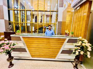 a man sitting at a bar in a restaurant at Hotel Ramawati Near Ganga Ghat, Haridwar in Haridwār