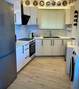 a kitchen with white cabinets and a stainless steel refrigerator at Apartment Xenia in Xiropigado
