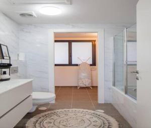 a white bathroom with a toilet and a shower at Magical 4BR APT With Panoramic Sea View l Mamad in Bat Yam