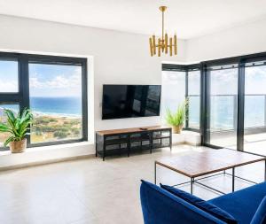 a living room with a blue couch and a table at Magical 4BR APT With Panoramic Sea View l Mamad in Bat Yam