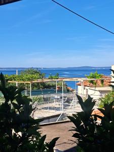 a white gate with the ocean in the background at Room Peričić in Strožanac +10 photos