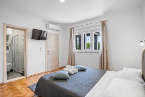 a bedroom with a bed with two pillows on it at Apartment & Rooms - Marina in Ploče