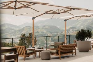 a patio with chairs and tables and umbrellas at Hotel Oberforsthof in Sankt Johann im Pongau +148 photos