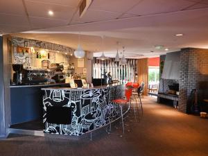 a bar in a restaurant with red stools at ibis Laval Le Relais D'Armor in Laval