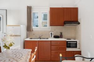 a kitchen with wooden cabinets and a white refrigerator at Merichas 7 Irida in Mérikhas +23 photos