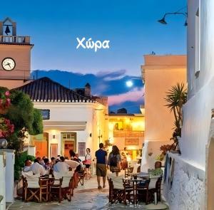 a group of people sitting at tables in a courtyard of a building at Merichas 7 Irida in Mérikhas