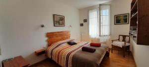 a bedroom with a bed and a chair and a window at La pause sous le pin B&B Chambres d'hôtes in Capestang +63 photos
