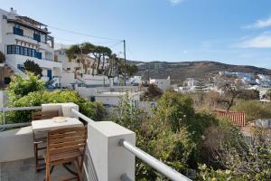a chair on a balcony with a view of a city at Driopida 5 Irida Kythnos in Mérikhas