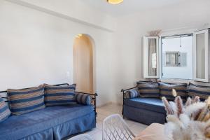 a living room with two blue couches and a window at Driopida 5 Irida Kythnos in Mérikhas
