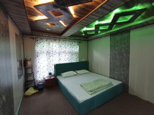 a bedroom with a bed with a green ceiling at Paris Home Stay in Keran +10 photos