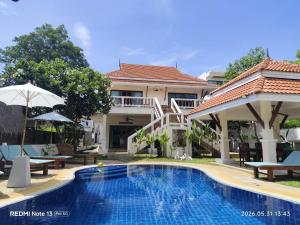 a swimming pool in front of a villa at Baan Dorkbua Villa in Bophut