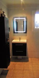 un baño con lavabo y espejo en Maison au centre de Camazen, en Pludual
