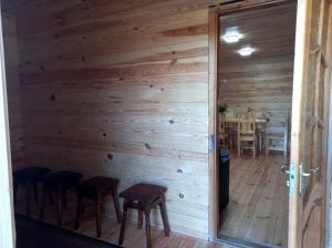 a room with a wooden wall with stools and a table at Плакуча верба in Svityazʼ