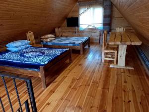 a room with two beds and a table in a cabin at Плакуча верба in Svityazʼ