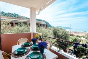 a table on a balcony with a view of the ocean at Corfu Glyfada Beach Apartment 58a in Corfu +23 photos