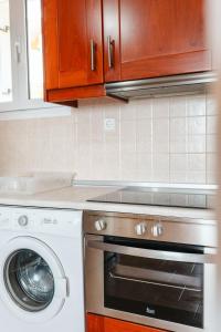 a kitchen with a stove and a washing machine at Corfu Glyfada Beach Apartment 58a in Corfu