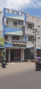 a building with signs on the side of a street at SRM Residency in Alāndurai +4 photos