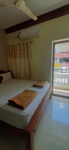 a small bed in a room with a window at SRM Residency in Alāndurai