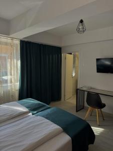 ein Schlafzimmer mit einem Bett, einem Schreibtisch und einem Stuhl in der Unterkunft Pension Recidency in Oradea