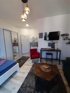 a living room with a couch a table and a red chair at FG Apartment in Sarajevo
