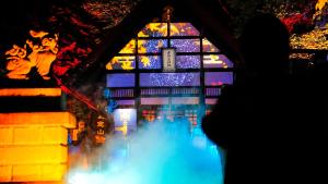 a person standing in front of a lit up building at Chalet Ivy Jozankei in Jozankei