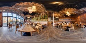 a restaurant with wooden tables and chairs and windows at JOESEPP´S HOTEL am Schweizerberg in Memmingen