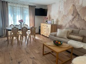 a living room with a couch and a table and chairs at Domek Golasówka in Muszyna