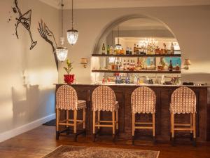 a bar with three chairs in front of it at Tintswalo Summer House in Glencairn +41 photos