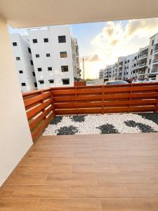 a balcony with a wooden fence and some buildings at Modern Cozy apartment in Boca Chica
