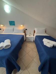 two beds in a room with blue sheets and towels at Hotel Dream in Rimini