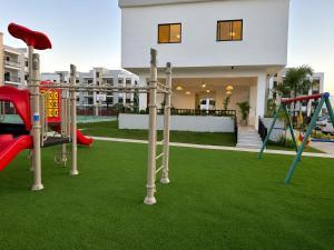 a playground in front of a house with a playground at Modern Cozy apartment in Boca Chica